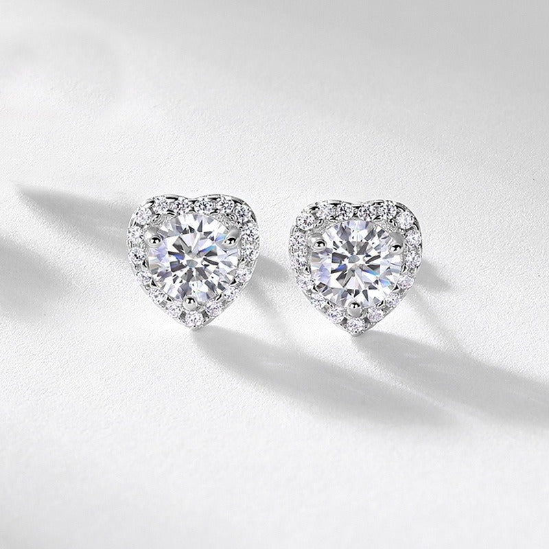 Heart-shaped diamond earrings on a light gray background