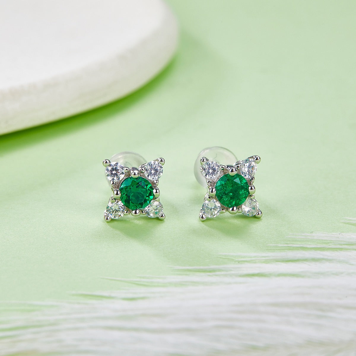 Round lab-grown emerald stud earrings with four clear halo accents