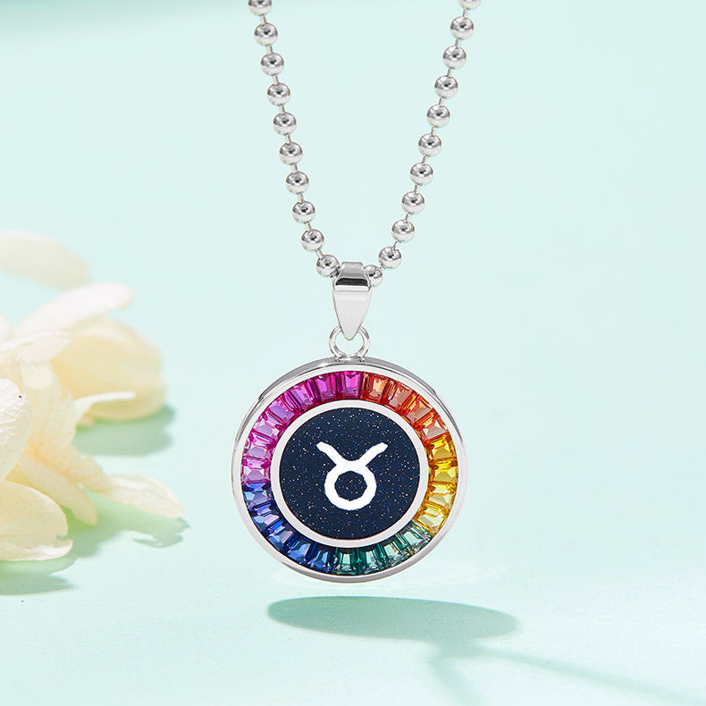 Necklace with a colorful pendant featuring a zodiac symbol on a light blue background