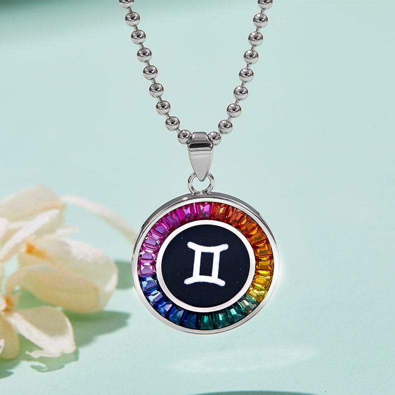 Necklace with a colorful gemstone pendant featuring the Gemini zodiac sign on a light blue background.