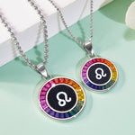 Two zodiac-themed necklaces with rainbow-colored stones on a light green background