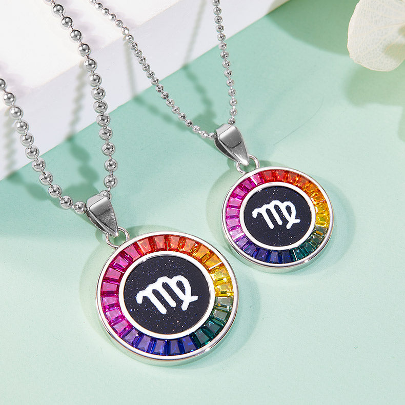 Two zodiac necklaces with colorful border and white symbol on a light green background