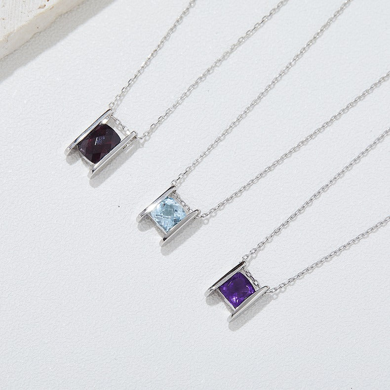 Three silver necklaces with square gemstones on a white background