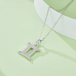 Silver necklace with a star-shaped pendant on a light green background