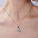 Silver necklace with a decorative pendant on a person's neck