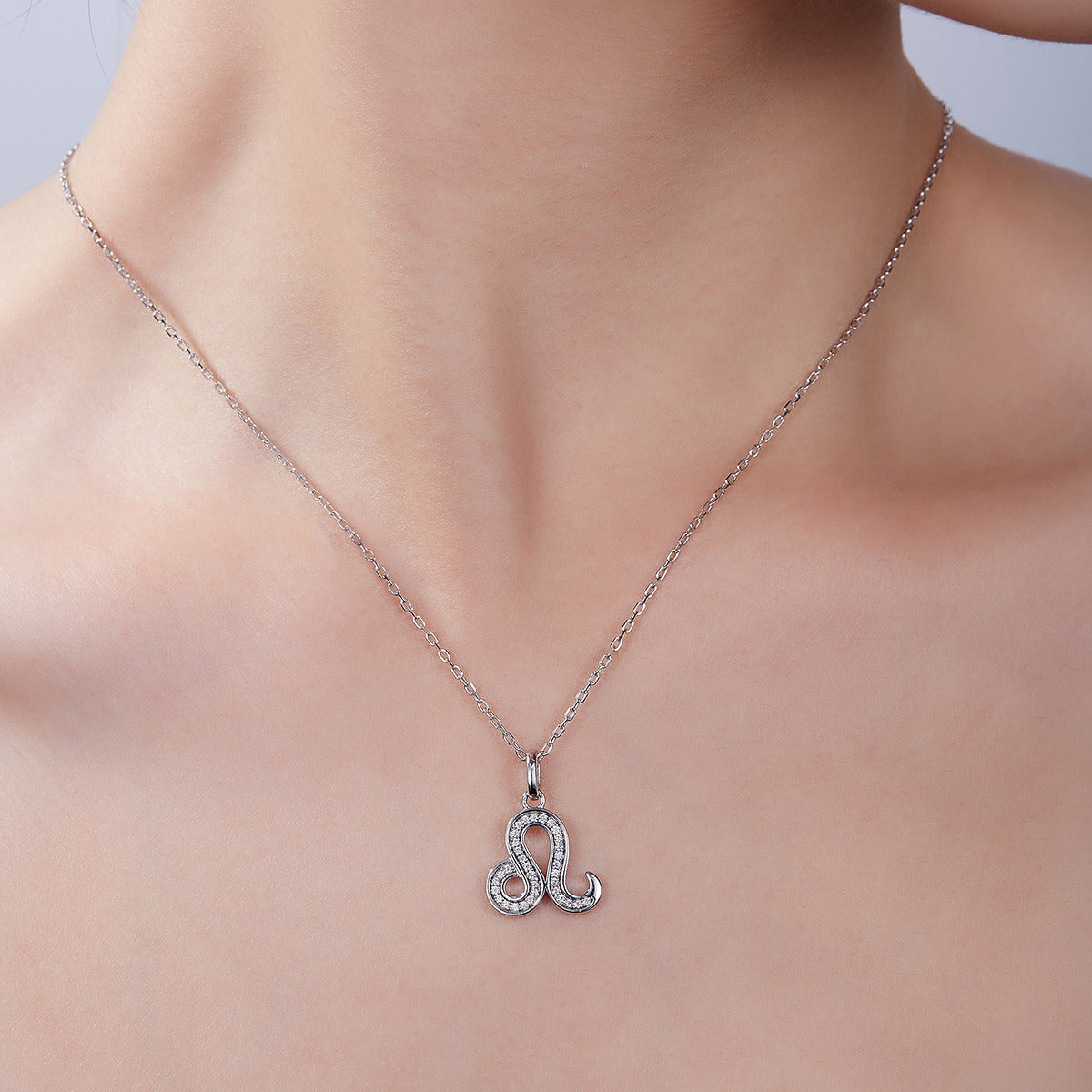 Silver necklace with a decorative pendant on a person's neck