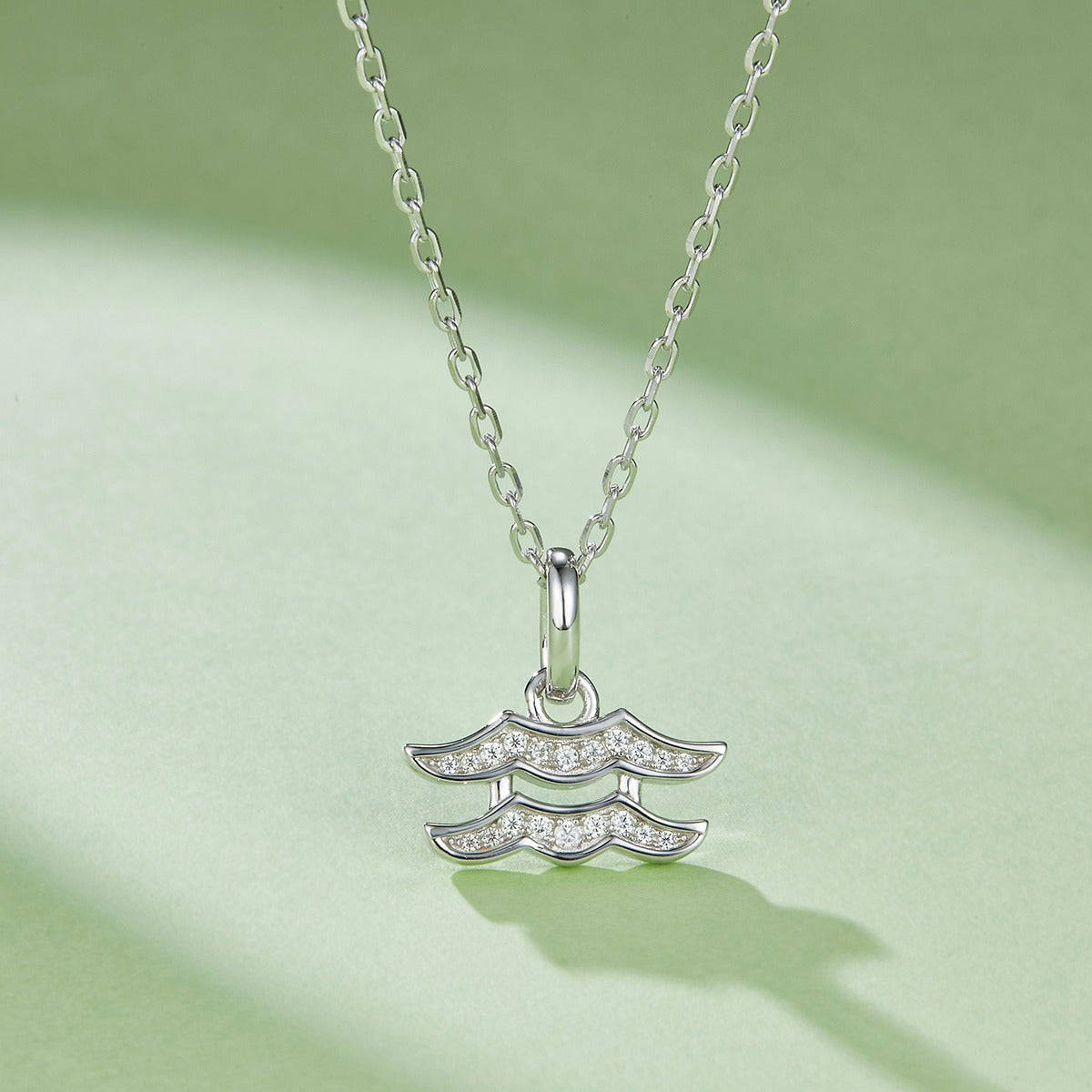 Silver necklace with a Aquarius Zodiac Pendant on a light green background