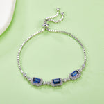 Silver bracelet with blue sapphire gemstones on a light green background