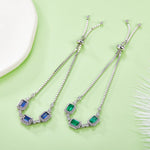 Two silver necklaces with gemstones on a light green background