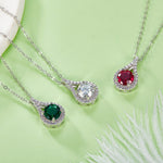 Two silver necklaces with gemstone pendants on a light green background