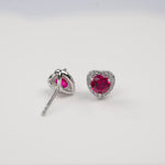 Heart-shaped red gemstone earrings on a white background