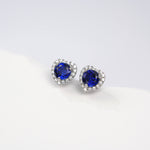 Heart-shaped blue gemstone earrings on a white background