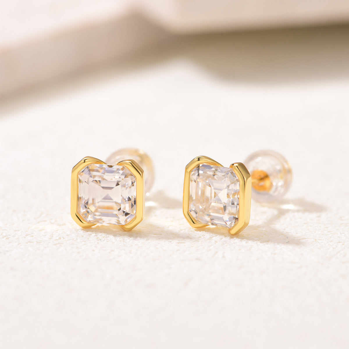 Asscher-cut stud earrings in yellow gold-plated finish, angled view