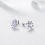 Pair of round moissanite halo stud earrings at an angle
