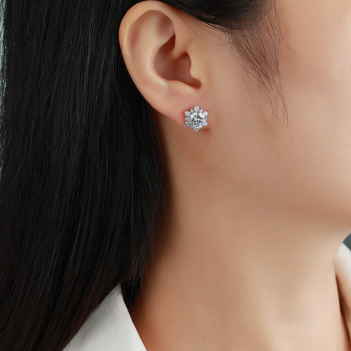 Round moissanite halo stud earring worn on ear